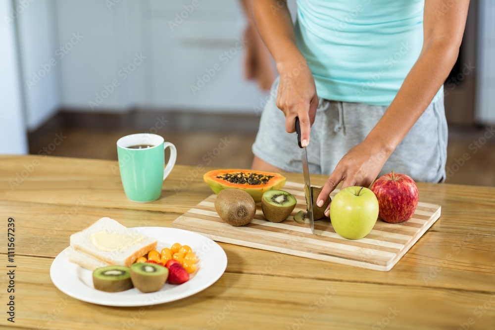 Woman cutting fruits at kitchen counter Woman cutting fruits at kitchen counter
