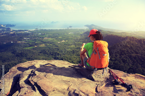 young woman hiker use smartphone  on seaside mountain top