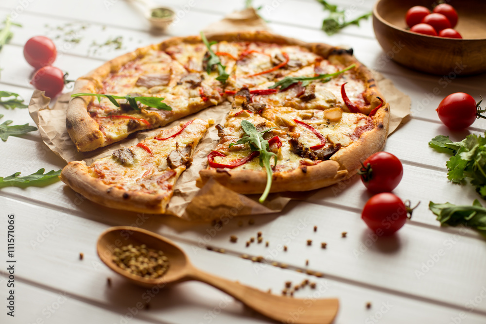 Delicious pizza with cheese and vegetables on white wooden background