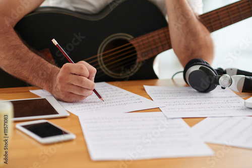 Close-up image of composer examining sheets with notes photo