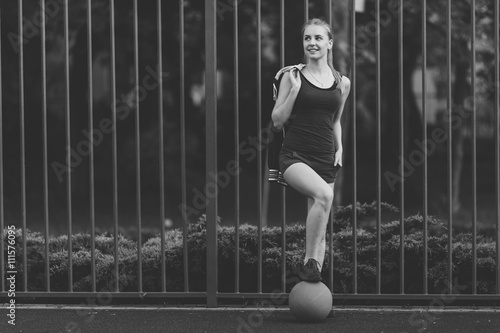 Sporty girl standing with basketball ball