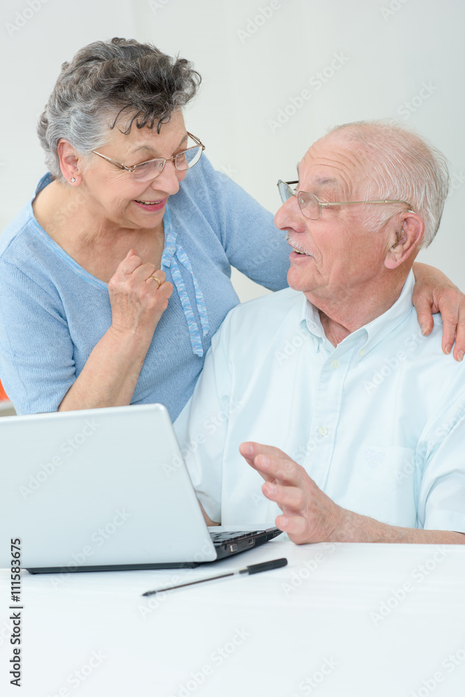 elderly couple in front of a laptop