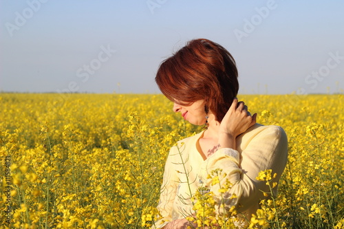 Girl in yellow blouse among fields of yellow rapeseed © watcherfox
