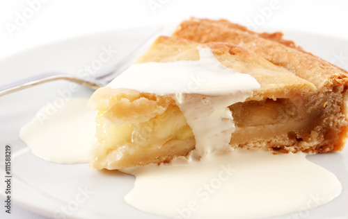 A slice of apple pie on a plate with cream on top