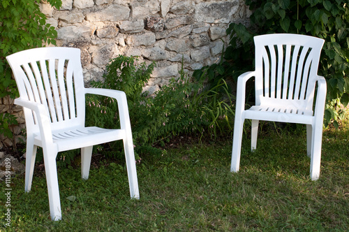 Two empty plastic chairs in the garden