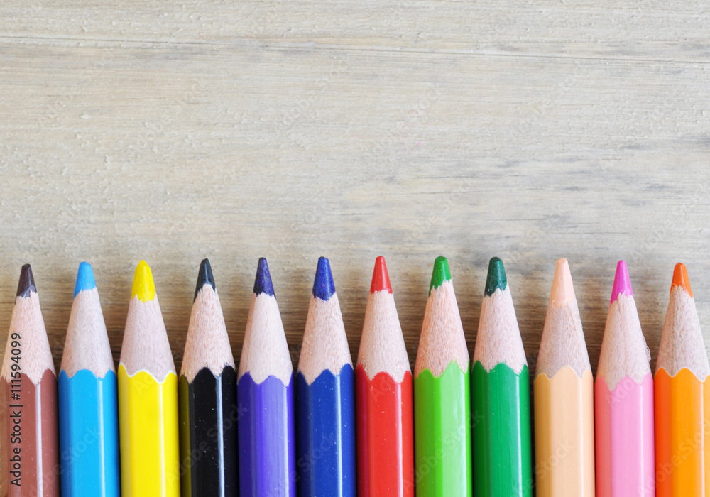 close up stack colour pencils on wooden background close up stack colour pencils on wooden background