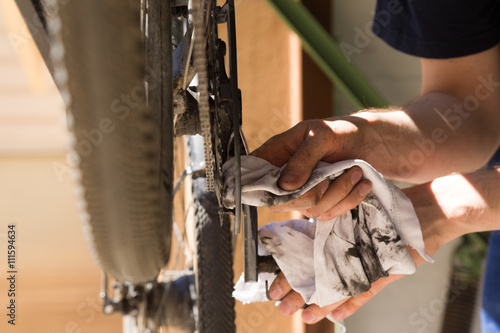 Mann putzt und repariert Kette seines Rades