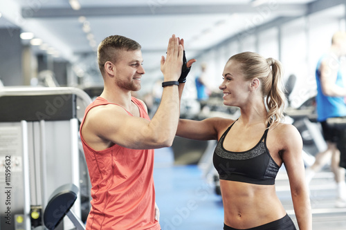 smiling man and woman doing high five in gym