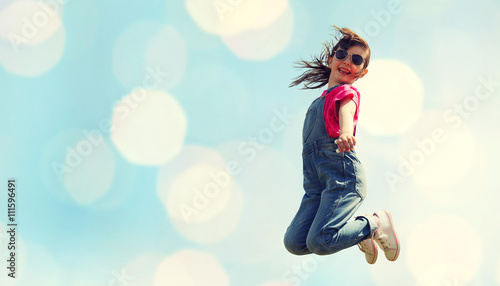 happy little girl jumping high over blue lights