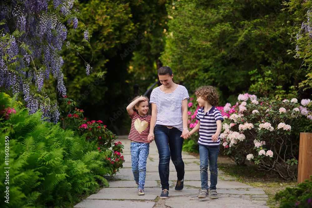 Fototapeta premium Young mother walking with her two children