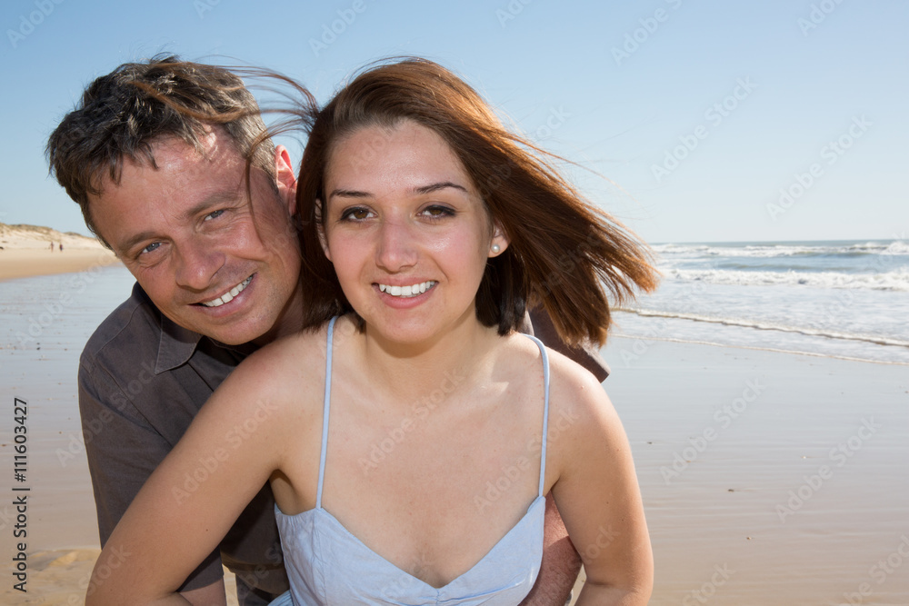 Couple smiling on the beach on a sunny day Couple smiling on the beach on a sunny day
