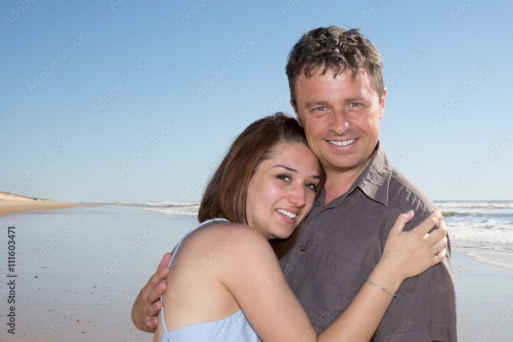 Beautiful couple embracing on the beach on vacation Beautiful couple embracing on the beach on vacation