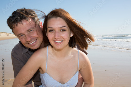 Couple smiling on the beach on a sunny day