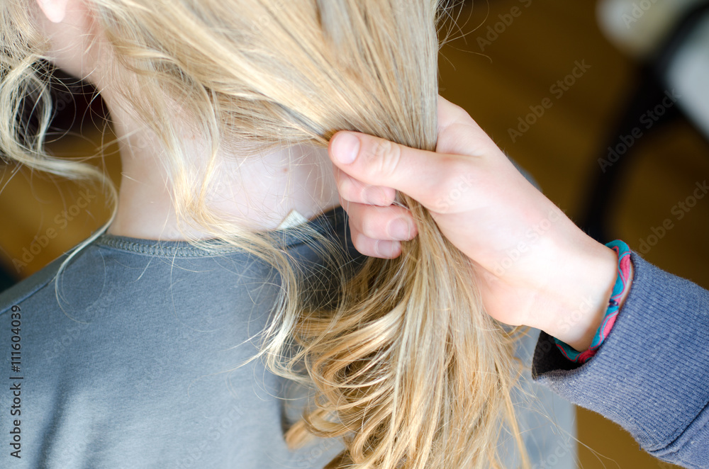 Obraz premium Girl getting sisters hair ready to put it into a ponytail