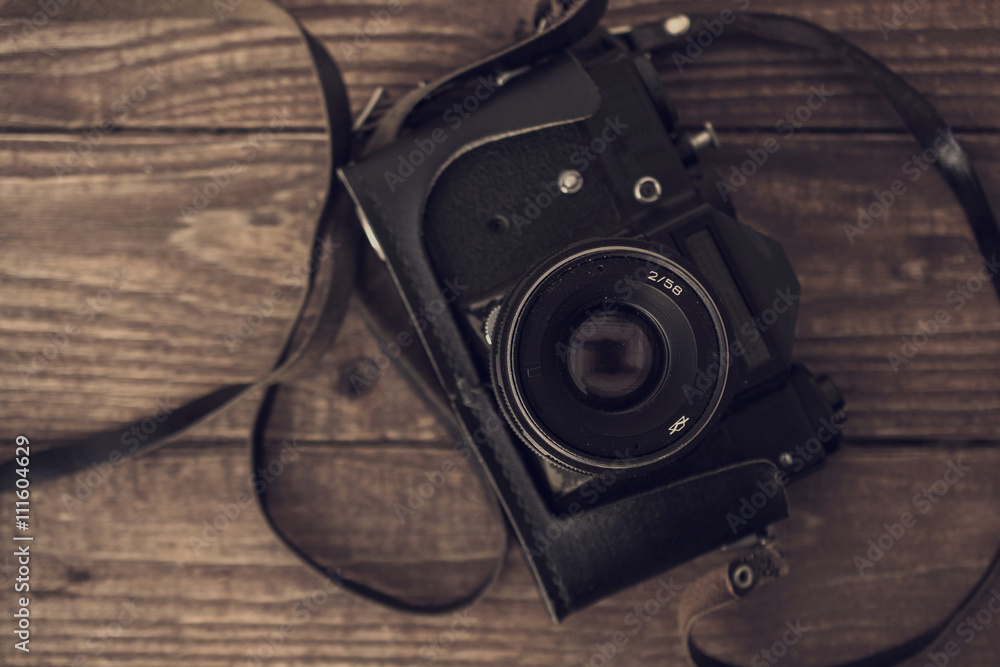 vintage analog camera on wooden background. top view