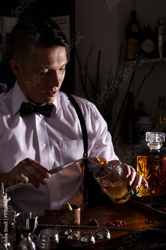 Young man working as a bartender in a nightclub cocktail bar