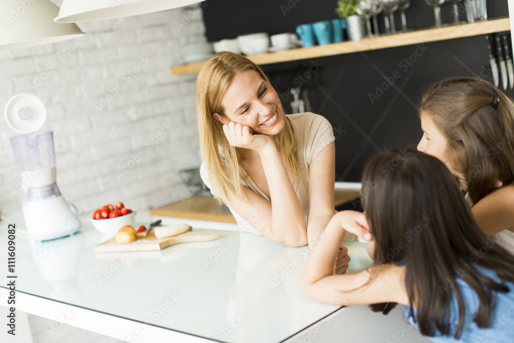 Woman and two girls in the kitchen Woman and two girls in the kitchen