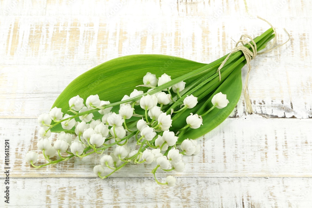 Foto Stock Bund Maiglöckchen auf hölzernem Hintergrund Adobe Stock
