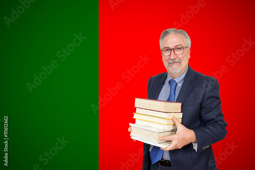 Senior teacher standing before of the portuguese flag