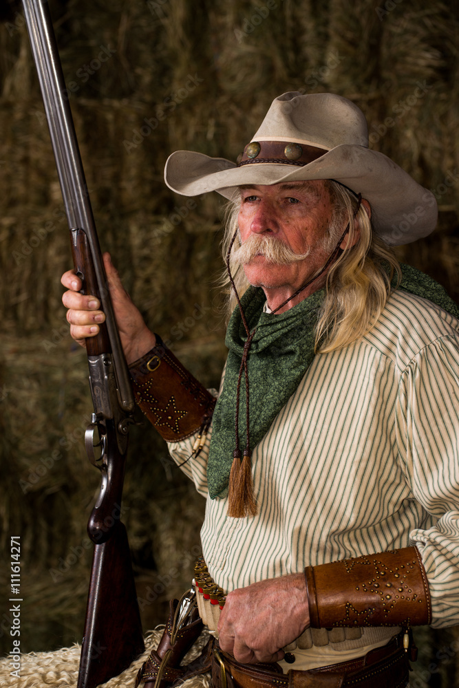 Authentic old west cowboy with shotgun hat and bandanna in stable Stock Photo Adobe Stock
