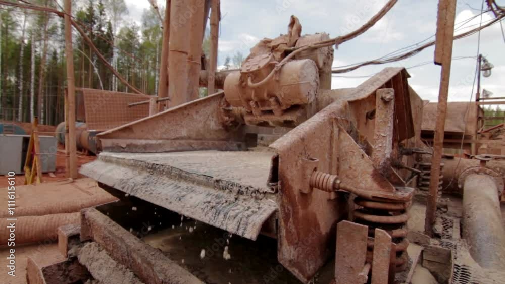 Shale shaker on oil rig separating drilling mud Shale shaker on oil rig separating drilling mud