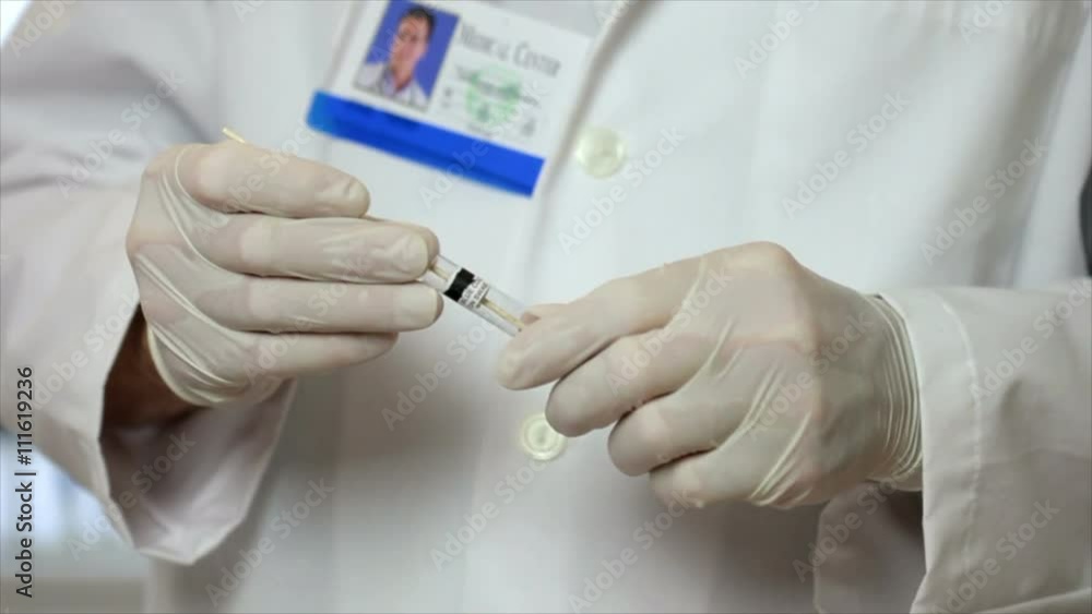 A laboratory technician or CSI investigator removes a swab from an ...