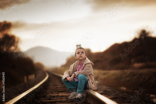 boy sitting on the railroad