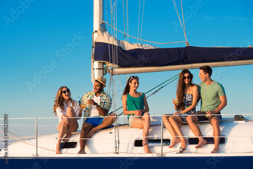 Men and women on yacht. Smiling people with drinks. Share your happiness. Piece of paradise. © DenisProduction.com