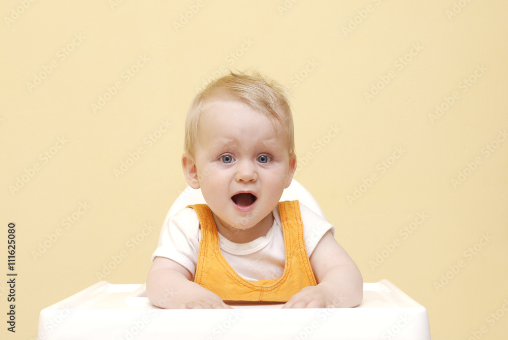 Portrait Of Happy Young Baby Boy In High Chair Portrait Of Happy Young Baby Boy In High Chair