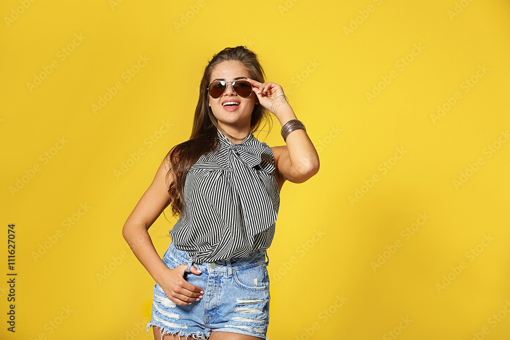 Pretty young woman in striped blouse on yellow background Pretty young woman in striped blouse on yellow background