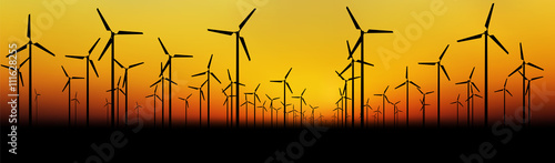 Vector silhouettes of wind turbines farm at sunset sky