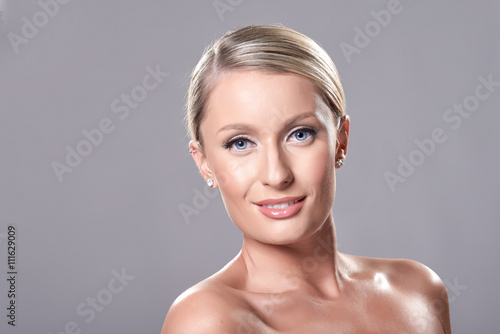 Portrait of beautiful blond model with blue eyes  on grey backgr