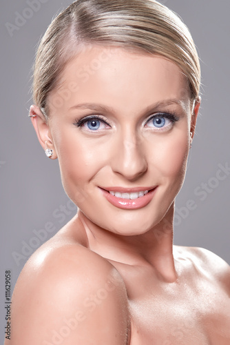 Portrait of beautiful blond model with blue eyes  on grey background