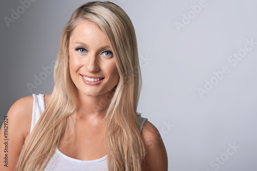 Portrait of beautiful blond model on grey background