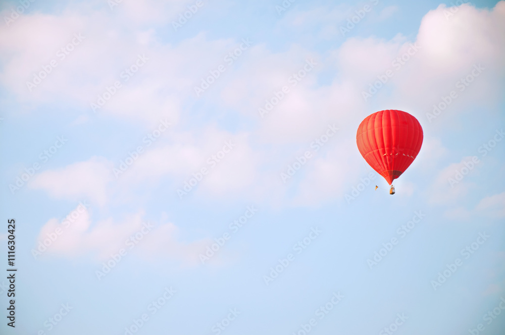 Red hot air balloon in blue sky with white clouds Red hot air balloon in blue sky with white clouds
