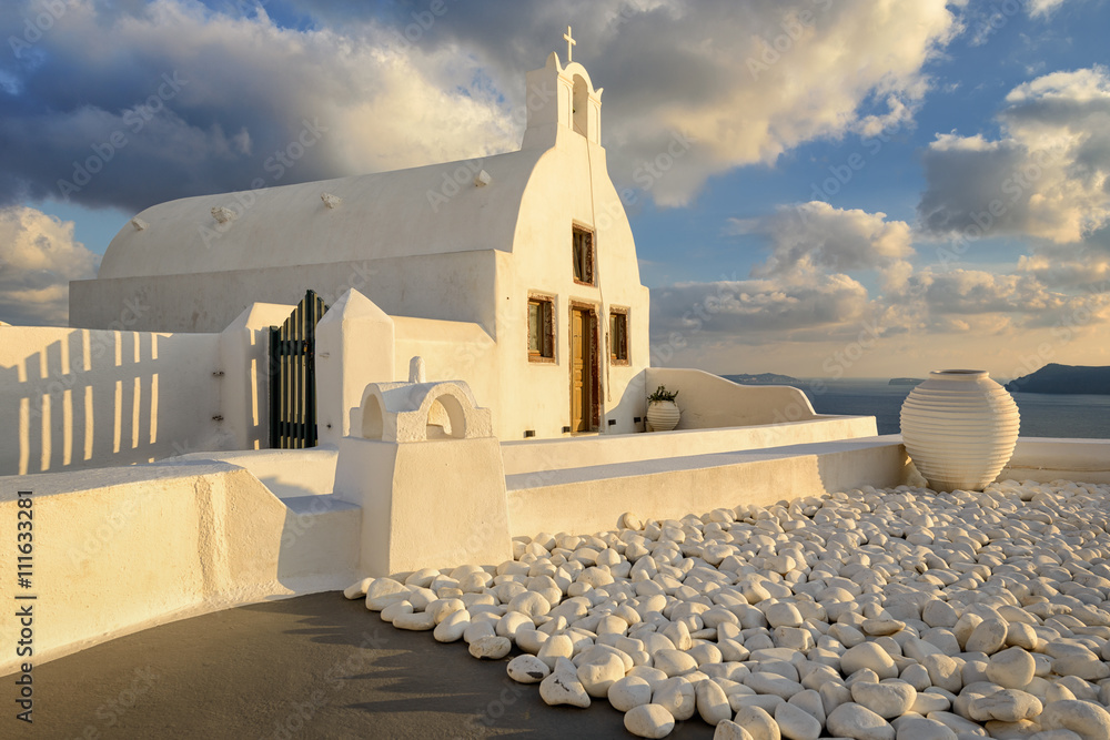 Fototapeta premium White church during sunset in Santorini, Greece