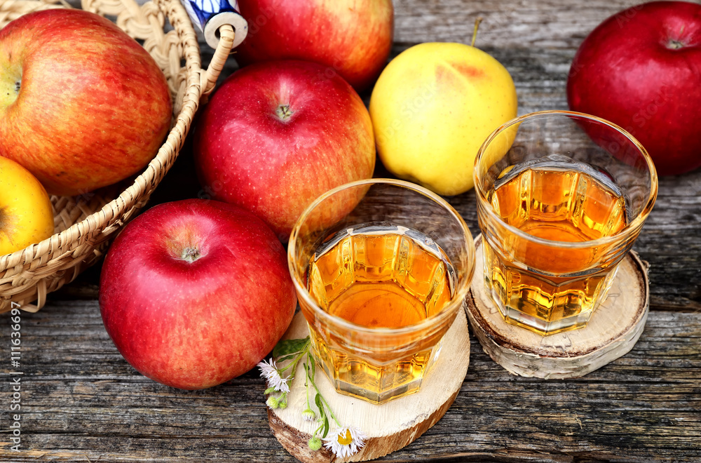Apple juice in two glass on old wooden table Apple juice in two glass on old wooden table