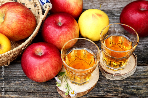 Apple juice in two glass on old wooden table