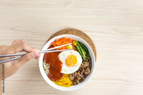 pouring sause to bibimbap , korean dish