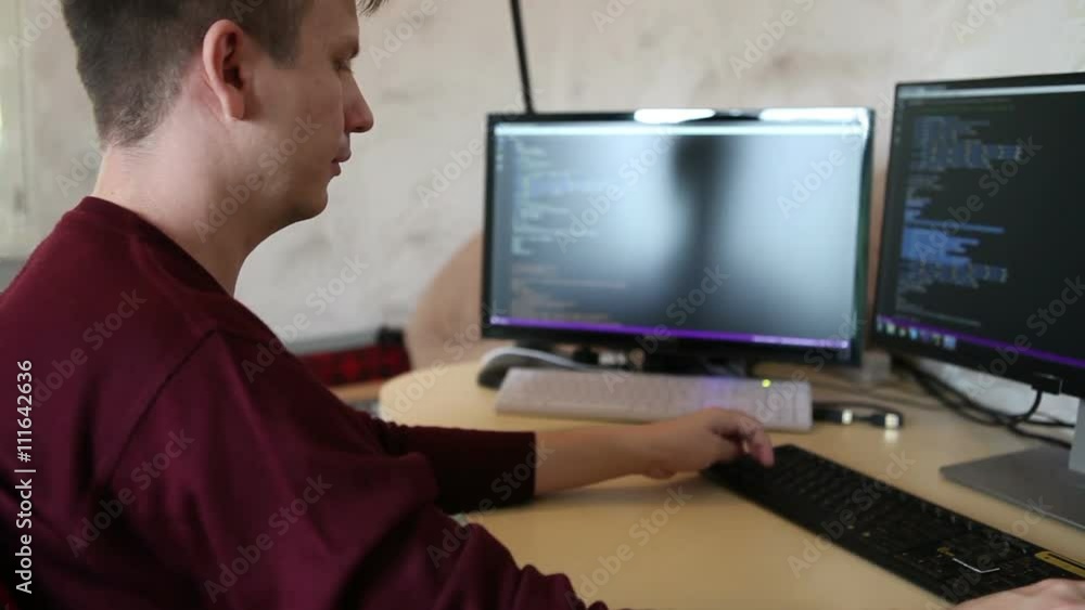 A man working at a computer programmer. Testing the program code A man working at a computer programmer. Testing the program code