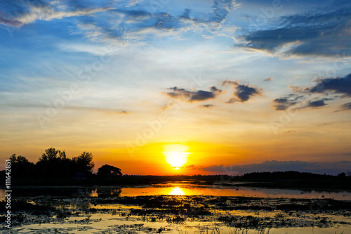 Sunset landscape with blue sky over the calm lake.
