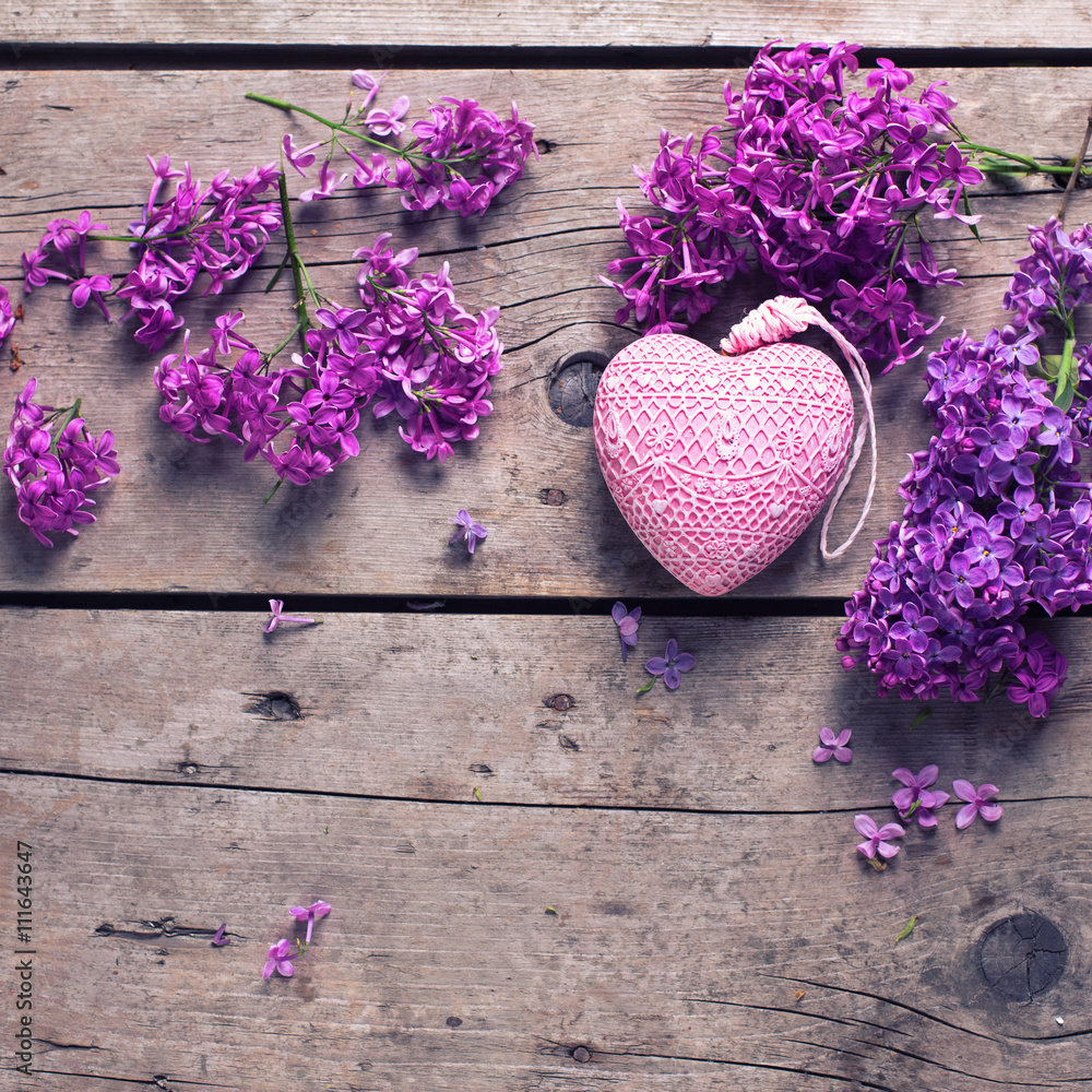 Fresh violet lilac flowers and decorative pink heart on aged Fresh violet lilac flowers and decorative pink heart on aged