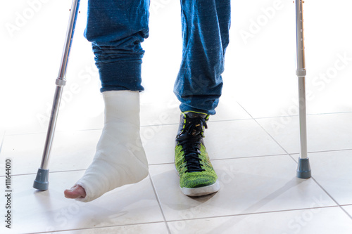 Young man with a broken ankle and a leg cast