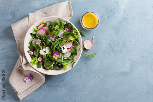 Spring salad with radishes, edible flower and sauce photo
