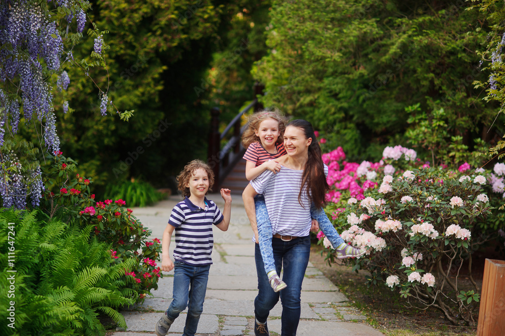Fototapeta premium Mother with the children in a lush park