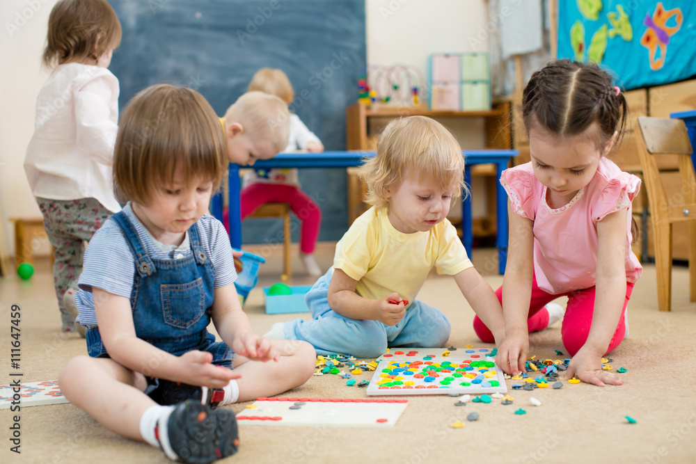 kids or children playing mosaic game in kindergarten room - obrazy, fototapety, plakaty 