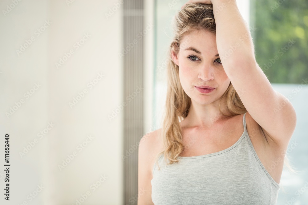 Confident smiling young woman with hand in hair Confident smiling young woman with hand in hair