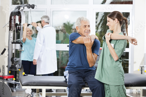Nurse Guiding Senior Patient In Arm Exercise At Rehab Center