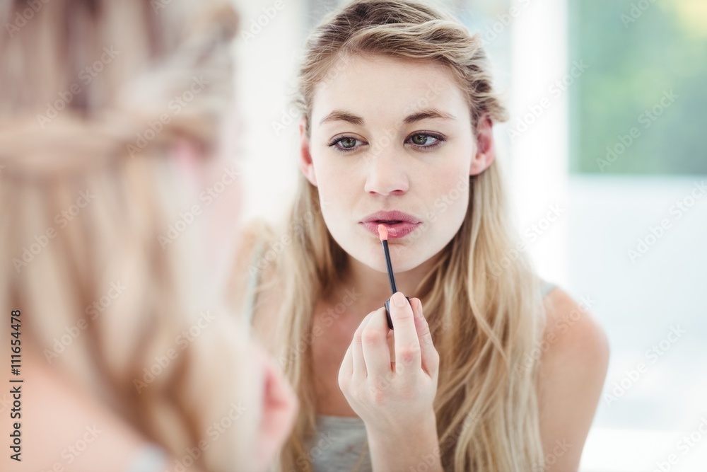 Young woman applying lip gloss Young woman applying lip gloss
