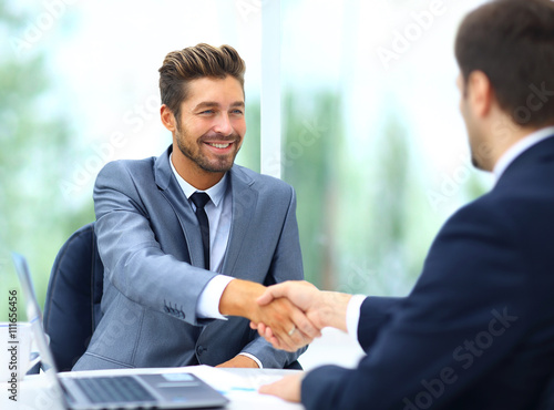 Two business colleagues shaking hands during meeting